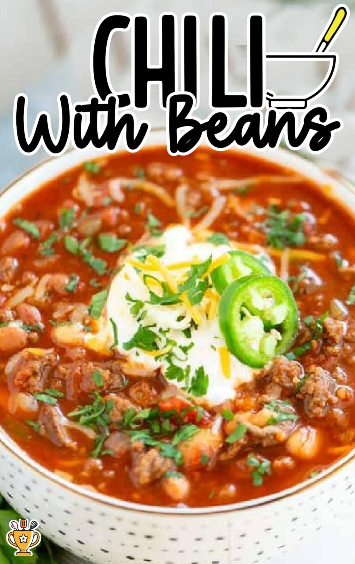 chili with beans in a bowl with sour cream and jalapeno 