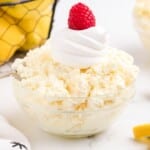 glass bowl with lemon fluff and a cherry on top