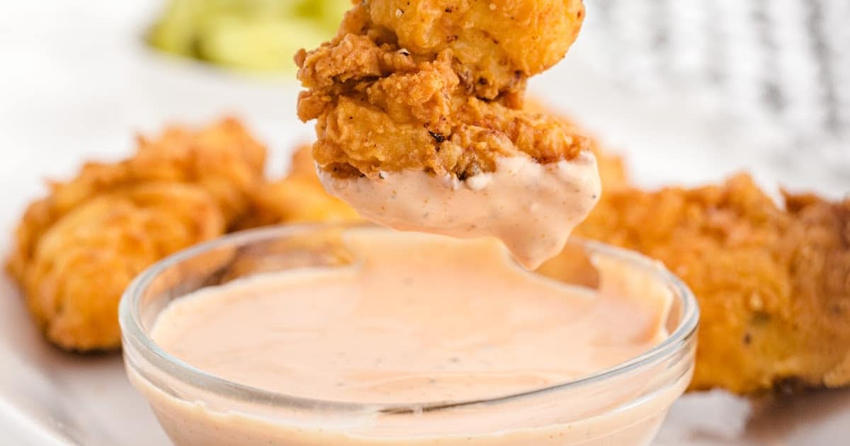 chicken strip dipping in the sauce