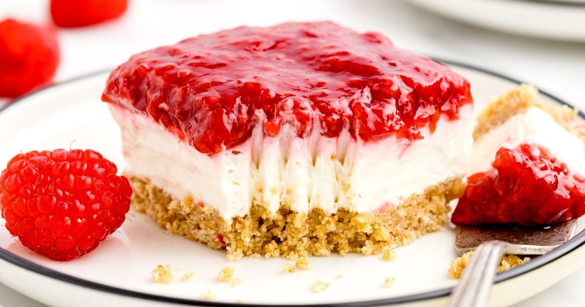 no bake raspberry cheesecake on a plate with a bite forked out of it