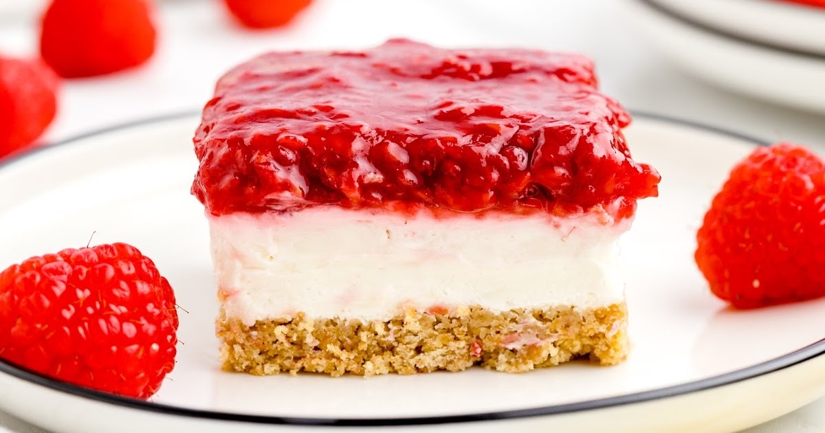 no bake raspberry cheesecake on a plate with a raspberries