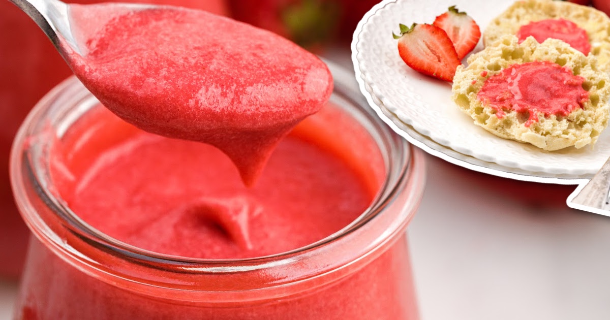 Strawberry Curd in a glass cup with a spoon grabbing a piece