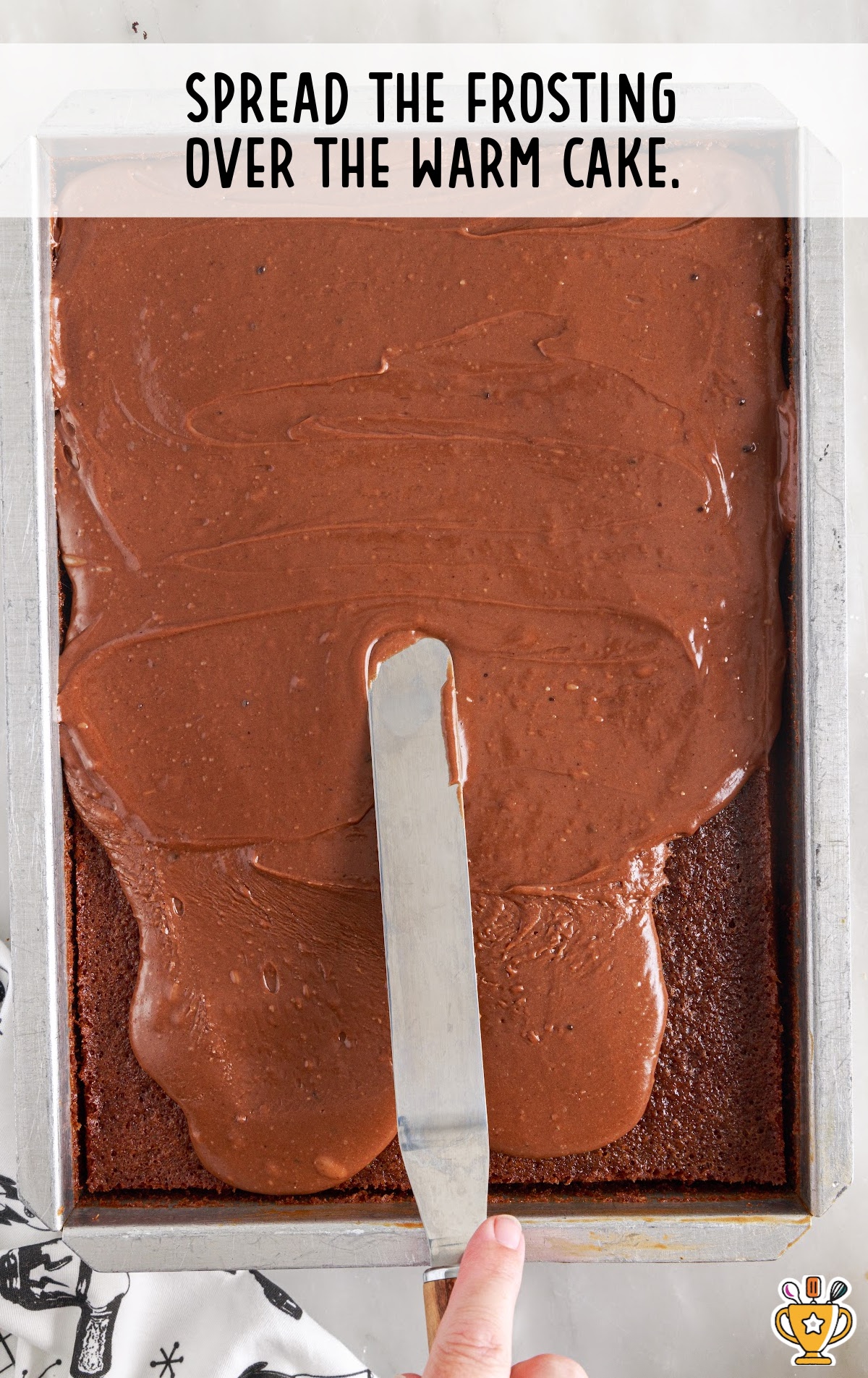 frosting poured over the cake and spread with spatula on a baking dish