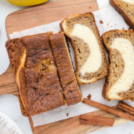 Banana Bread with slices cut on a wooden cutting board
