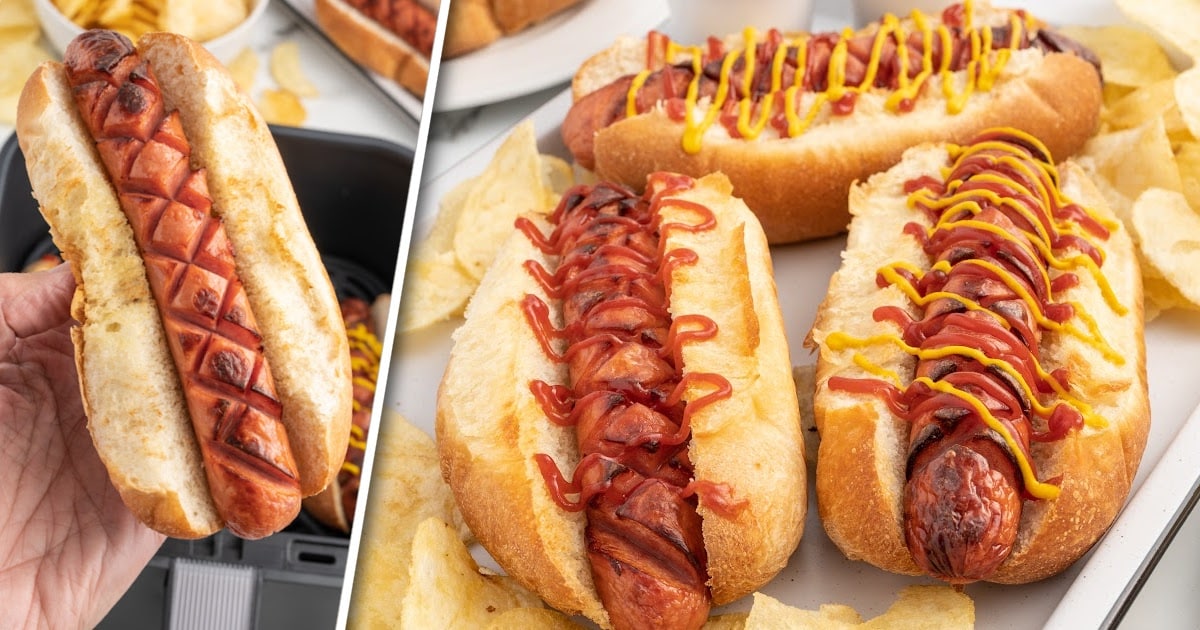 Hot Dogs topped with ketchup and mustard in an air fryer next to a bowl of chips