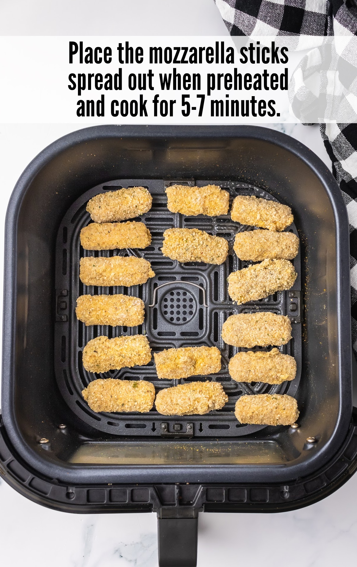 Mozzarella sticks spread out on the air fryer and cooked