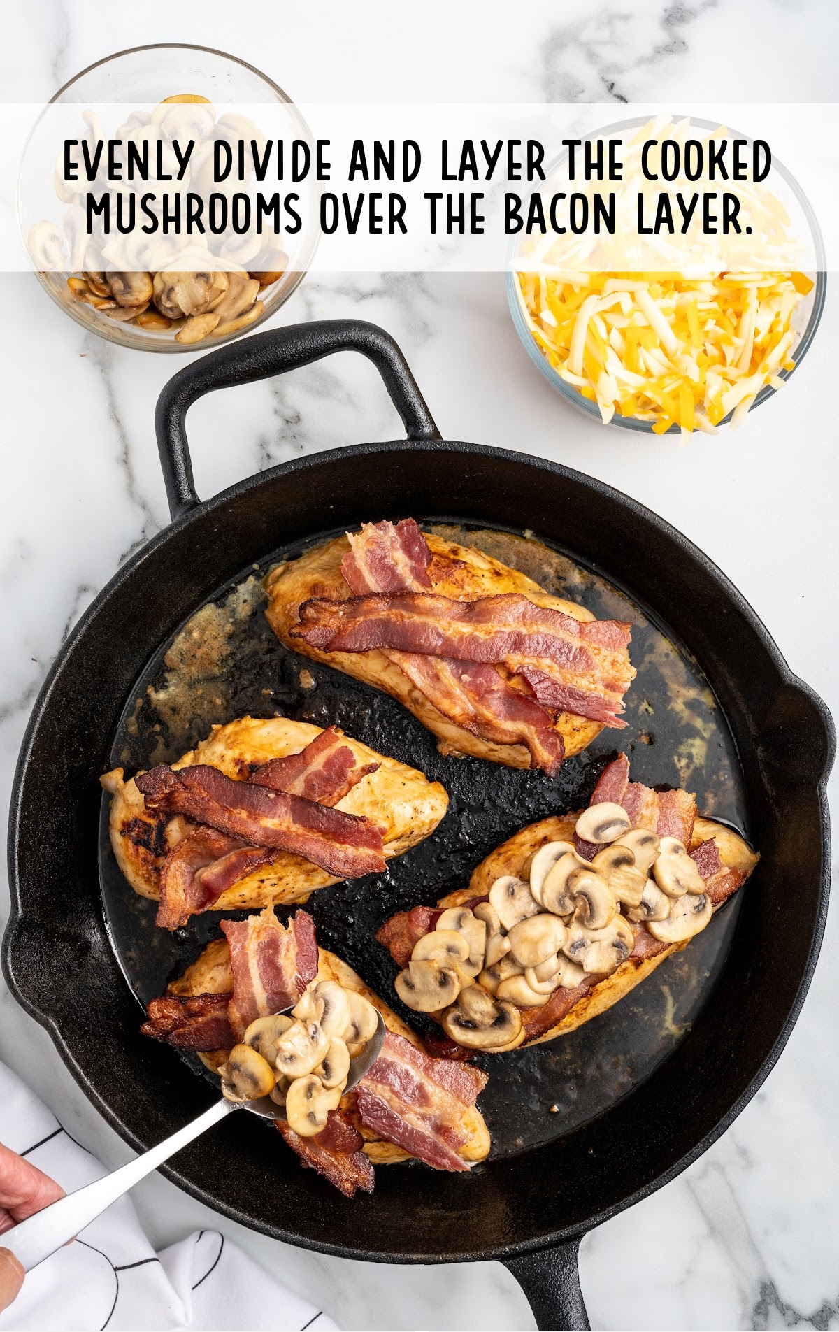 cooked mushrooms placed on top of the bacon layer in the skillet