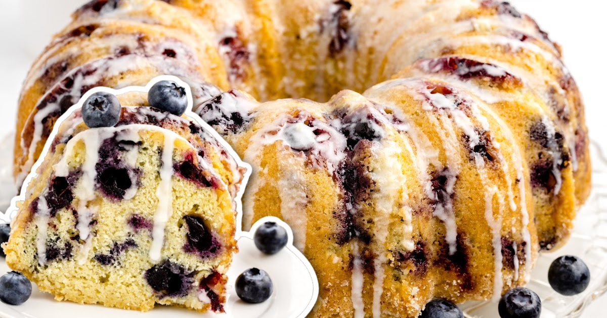 close up shot of a loaf of pound cake topped with glaze and blueberries