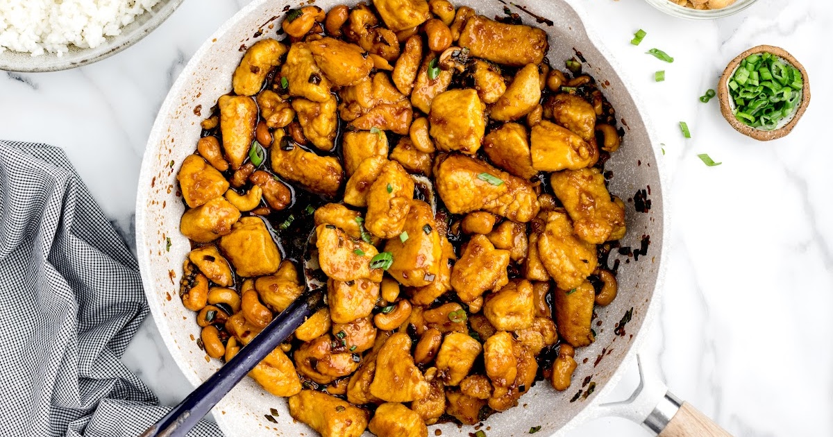 close up shot of a skillet full of Tuscan Chicken with a spoonful of sauce