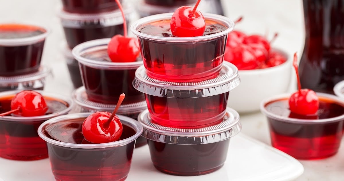 a close up shot of Cherry Coke Jello Shots stacked on top of each othe