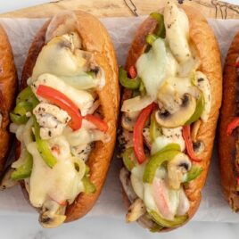 close up shot of philly cheesesteak sloppy joes with provolone and green peppers on buns