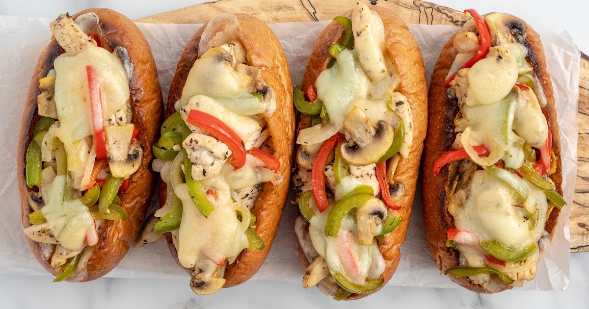close up shot of philly cheesesteak sloppy joes with provolone and green peppers on buns