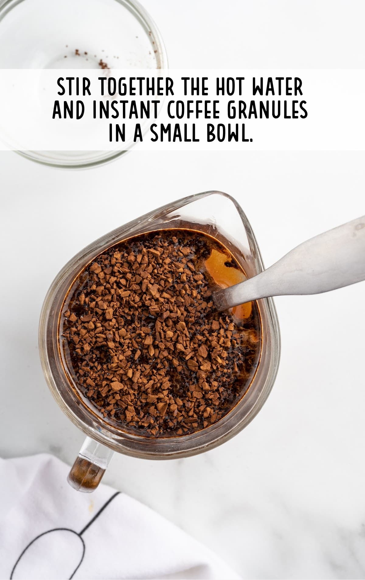 hot water and instant coffee granules combined in a bowl 