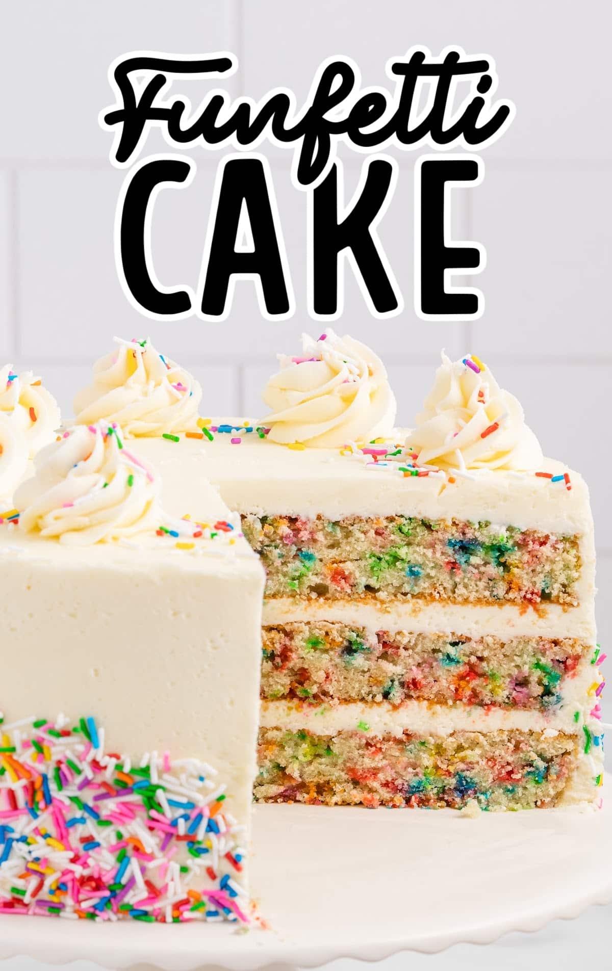 Funfetti Cake on a cake stand with a slice taken out of it