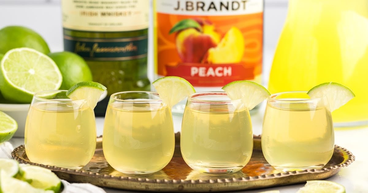 a close up shot of Green Tea Shots in a glass cup garnished with a slice of lime on a tray