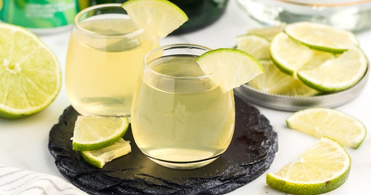 a close up shot of Green Tea Shots in a glass cup garnished with a slice of lime on a tray