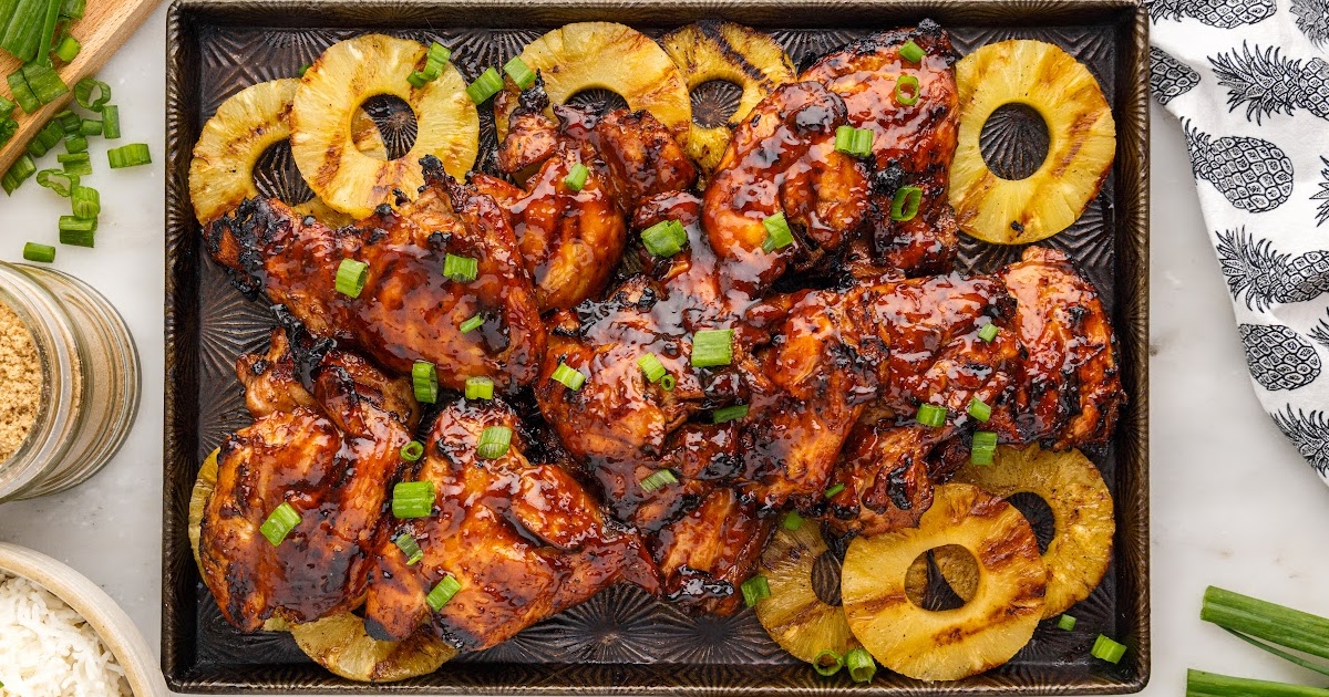 a baking tray of Huli Huli Chicken with slices of pineapples