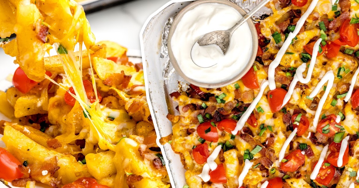 close up overhead shot of a aluminum foil of Dirty Fries topped with cheese then garnished with bacon bits and green onions