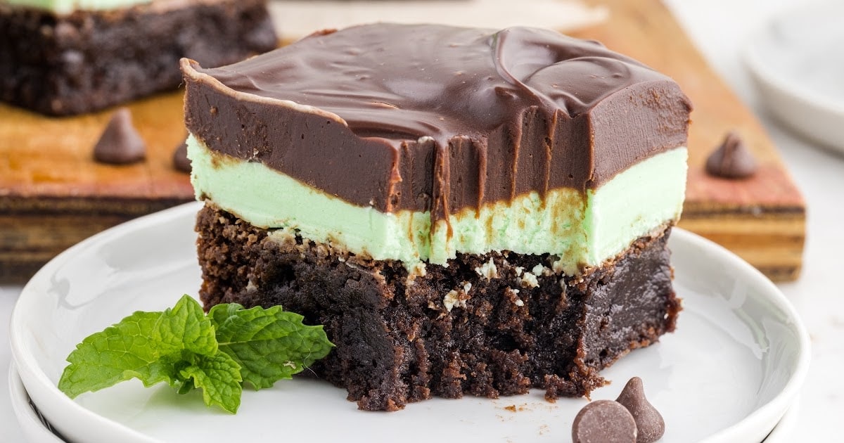 close up shot of a slice of Mint Chocolate Brownies with a mint leaf on a plate