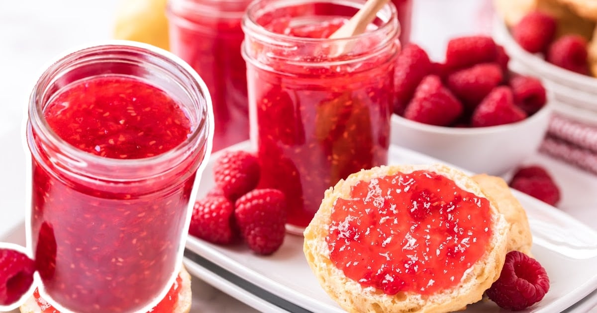 close up shot of a jar of Raspberry Freezer Jam on an english muffin