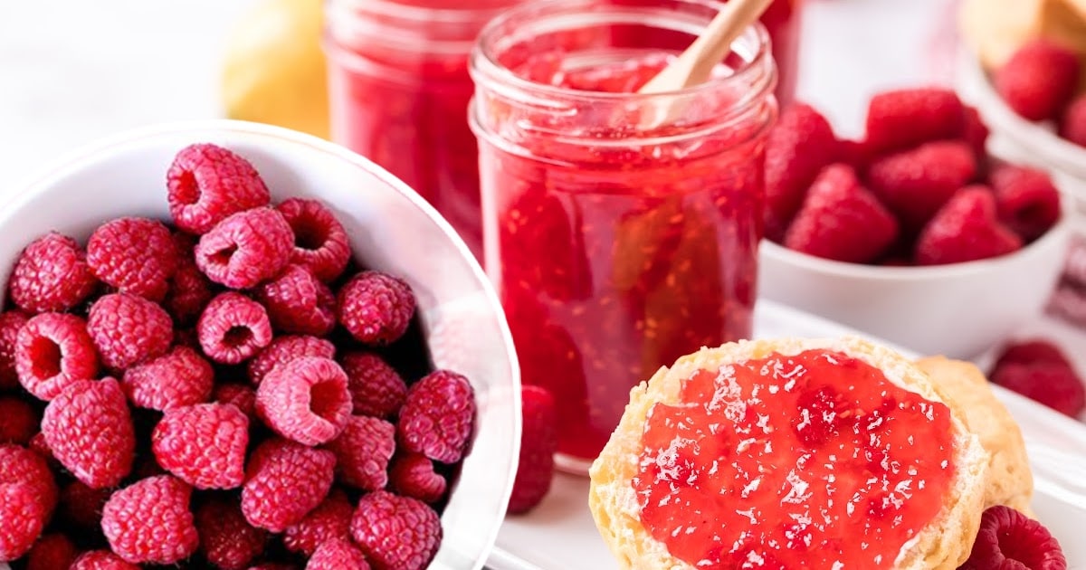 close up shot of a jar of Raspberry Freezer Jam with fresh raspberries 