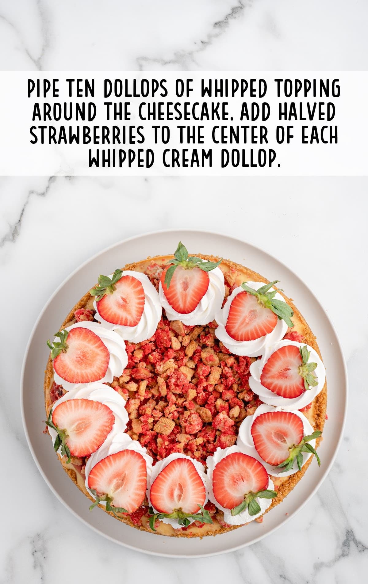 strawberry crunch cheesecake topped with whipped cream and fresh sliced strawberries