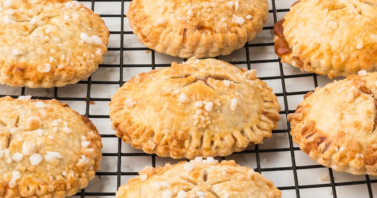 close up shot of a bunch of Air Fryer Apple Pies with a bite taken out of one of them