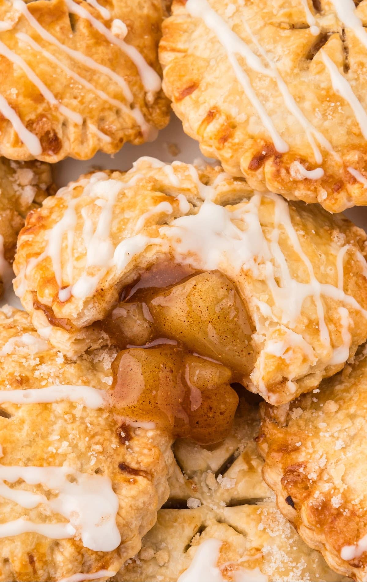 close up shot of a bunch of Air Fryer Apple Pies with a bite taken out of one of them
