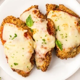 White plate containing three pieces of air fryer chicken parmesan