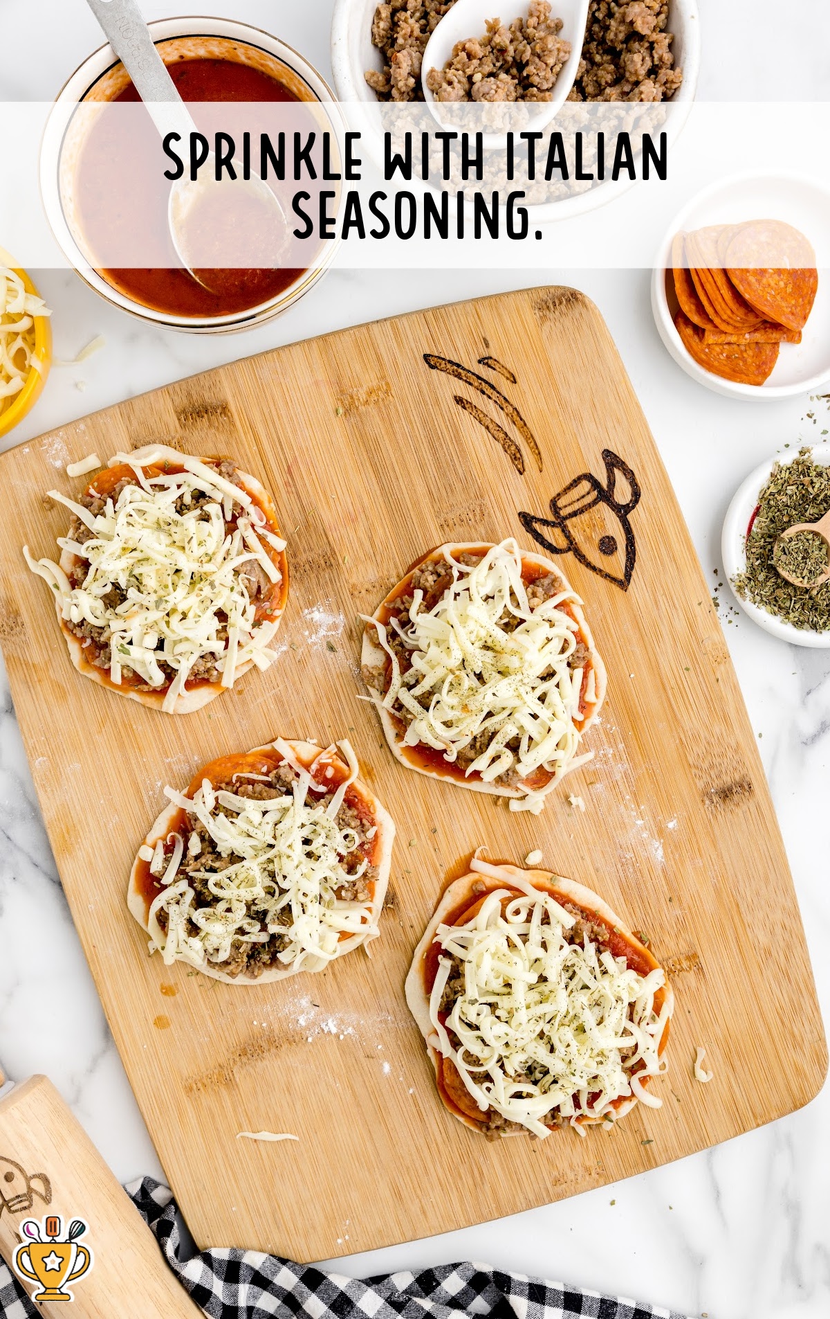 pizzas being sprinkled with Italian seasoning on a wooden board