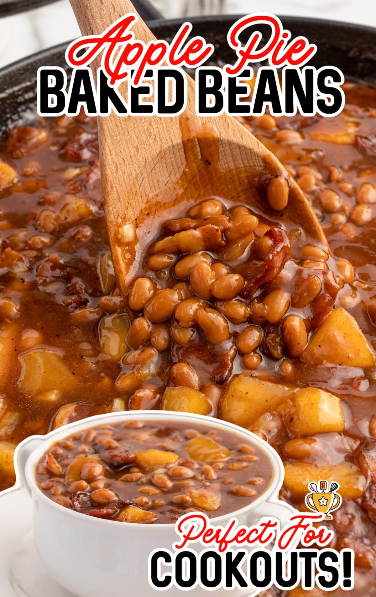 a skillet of Apple Pie Baked Beans with a wooden spoon