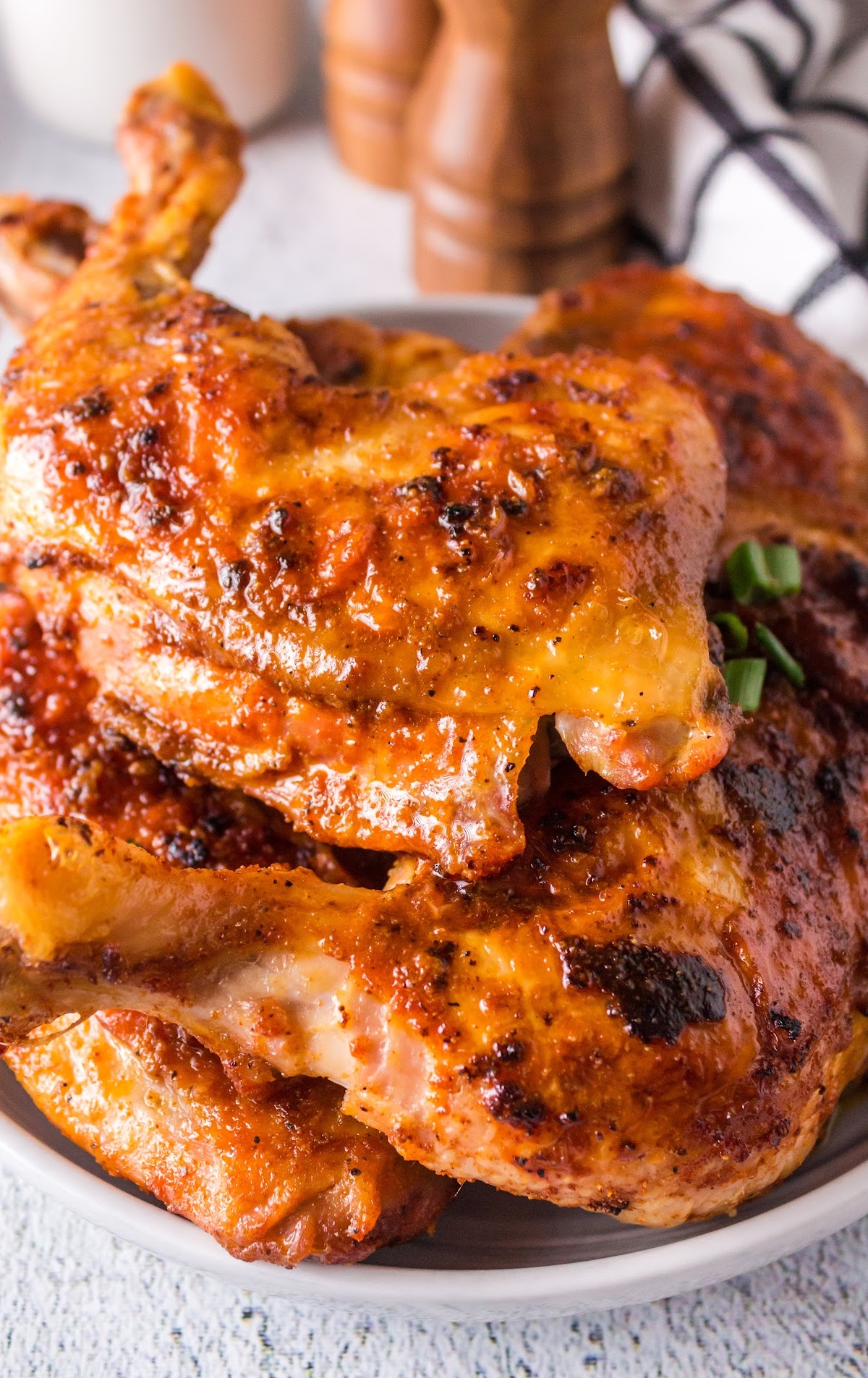 close up shot of Baked Chicken Legs garnished with green onions on a plate