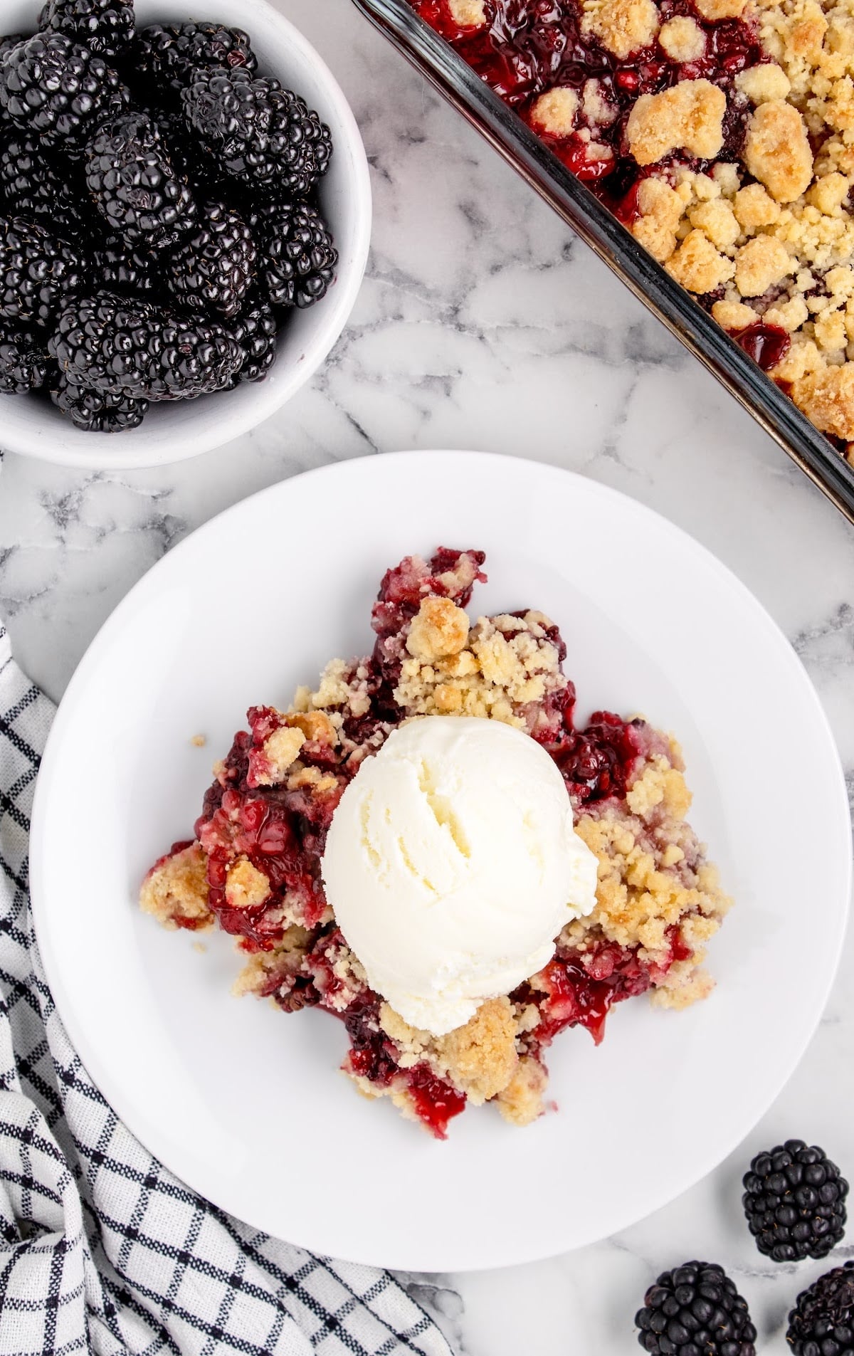 close up shot of a serving of peach dump cake topped with whipped cream