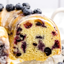 a pound cake on a serving platter next to a cup of coffee