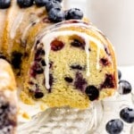 a sliced cake with blueberries and glaze drizzle