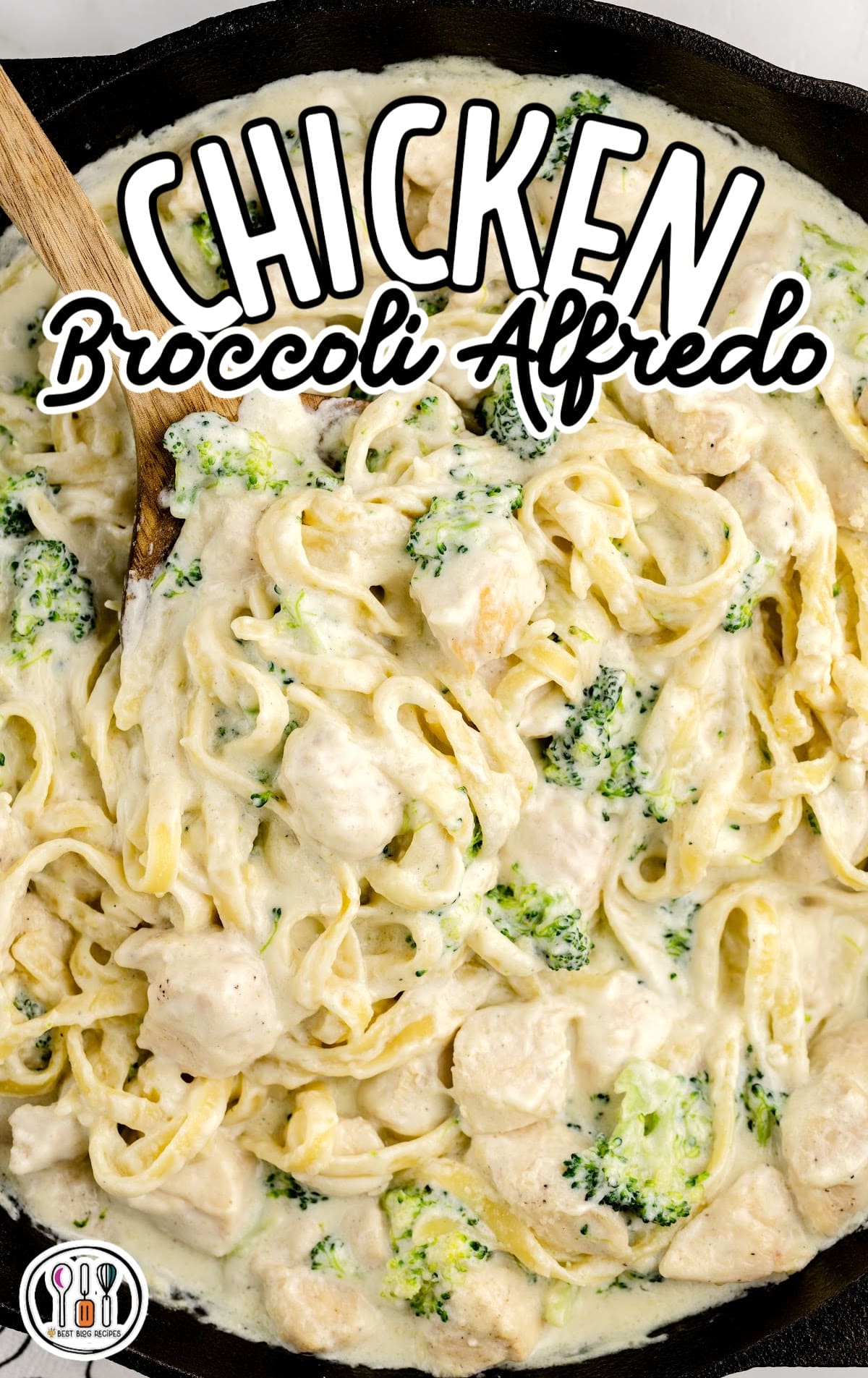 overhead shot of a wooden spoon grabbing a piece of Chicken Broccoli Alfredo