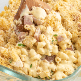 A pan of chicken cordon bleu casserole with a serving spoon lifting a scoop out.