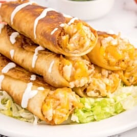 a stack of chicken flautas on a serving plate