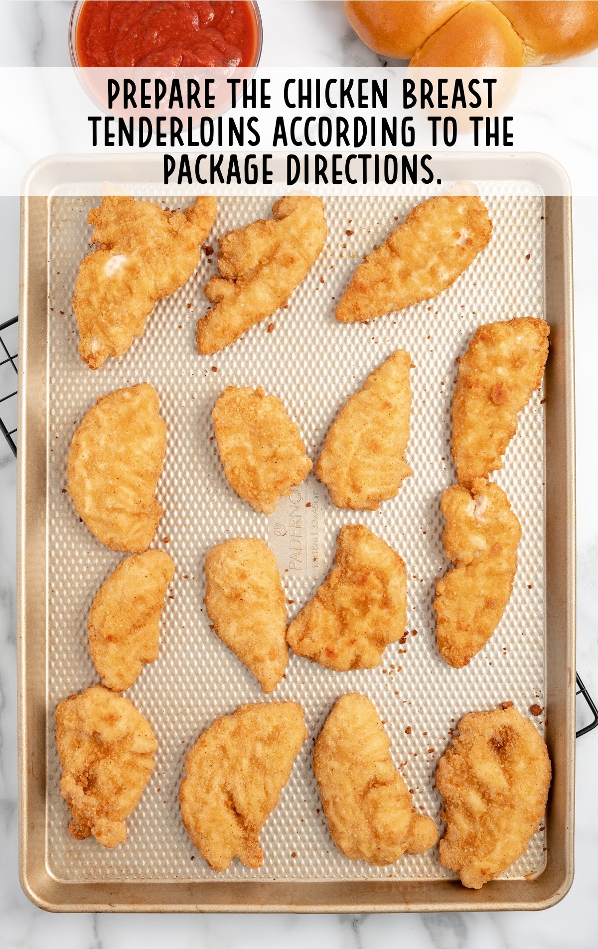chicken breast tenderloins baked on a baking sheet