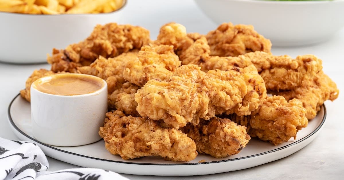 close up shot of a bunch of Chicken Tenders on a plate