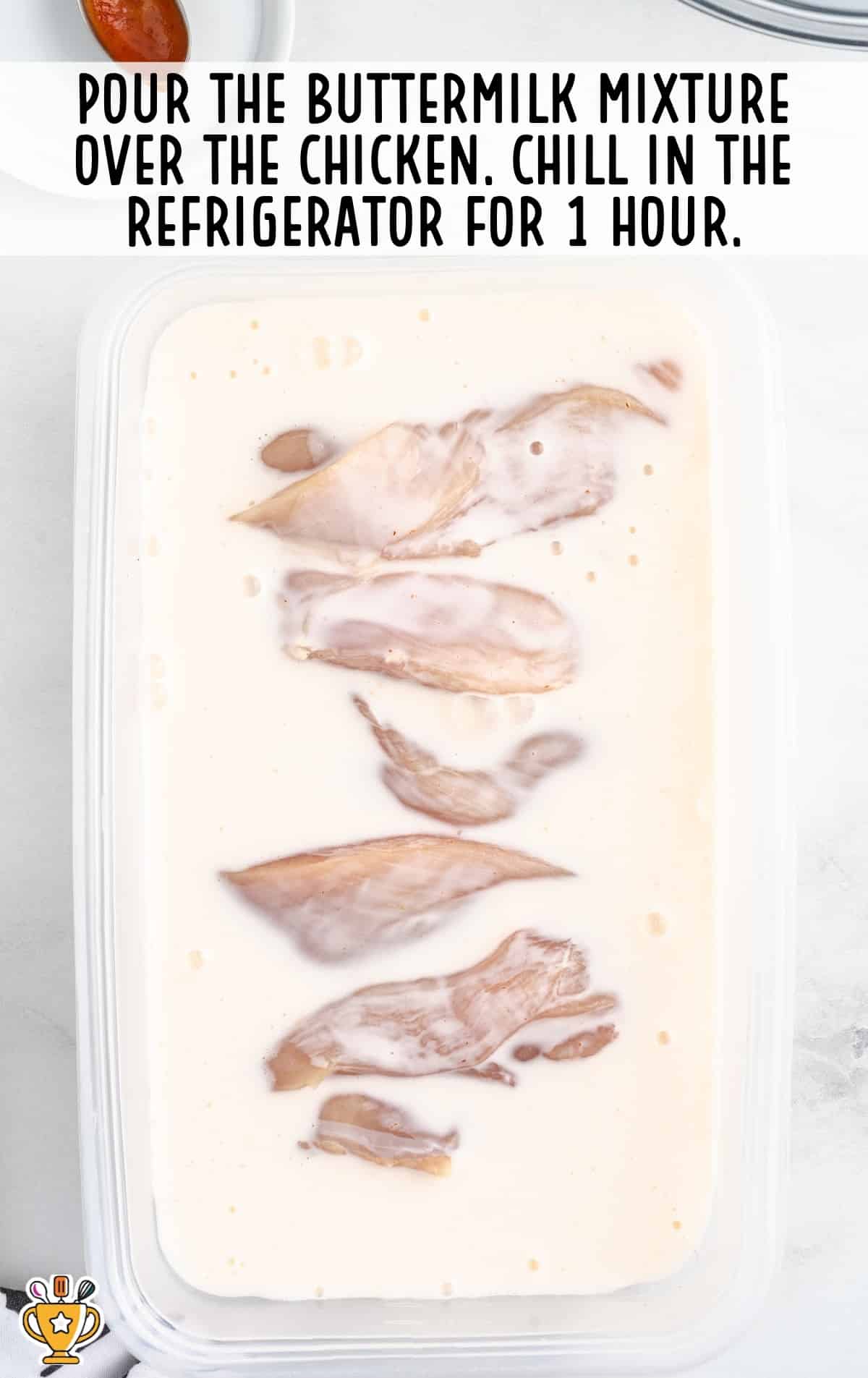 pieces of chicken in a container of buttermilk mixture