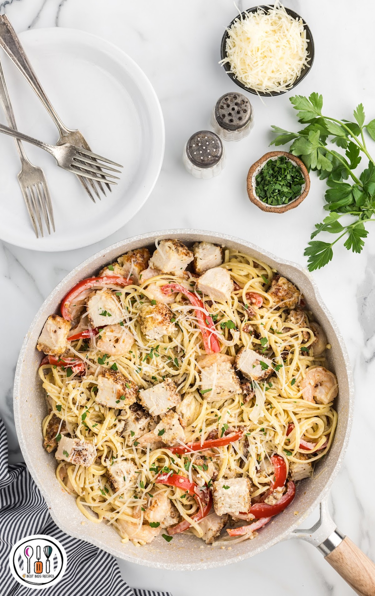 overhead shot of a pan of Carbonara Pasta topped with bacon bits, cheese, and parsley