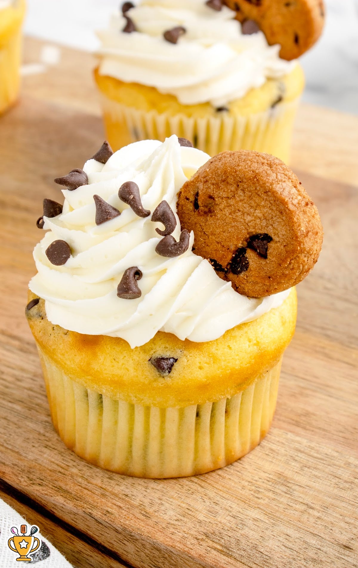 chocolate chips sprinkled on top of the cupcake and garnished with mini chocolate chip cookie