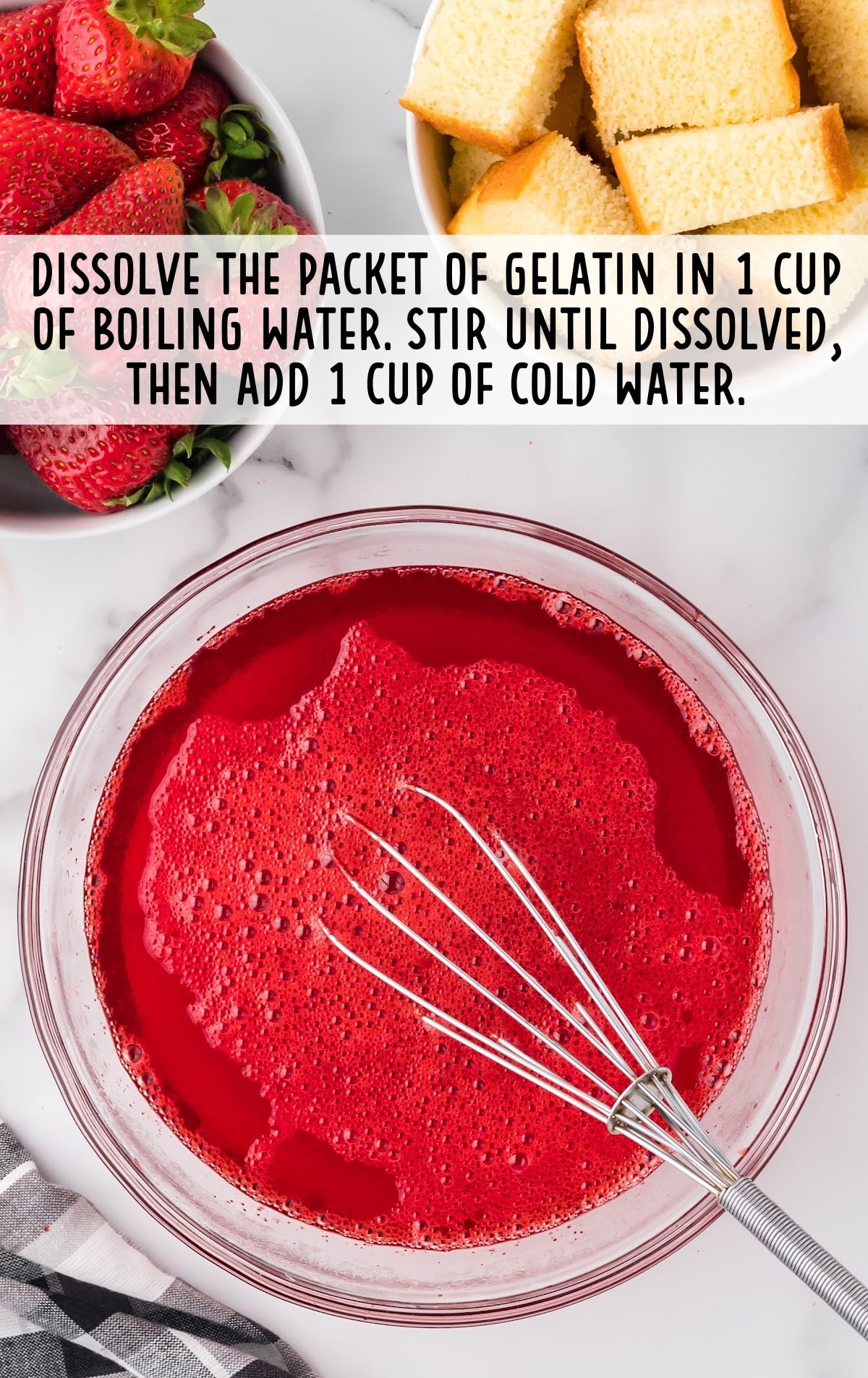 red gelatin dissolved into a bowl of boiling water