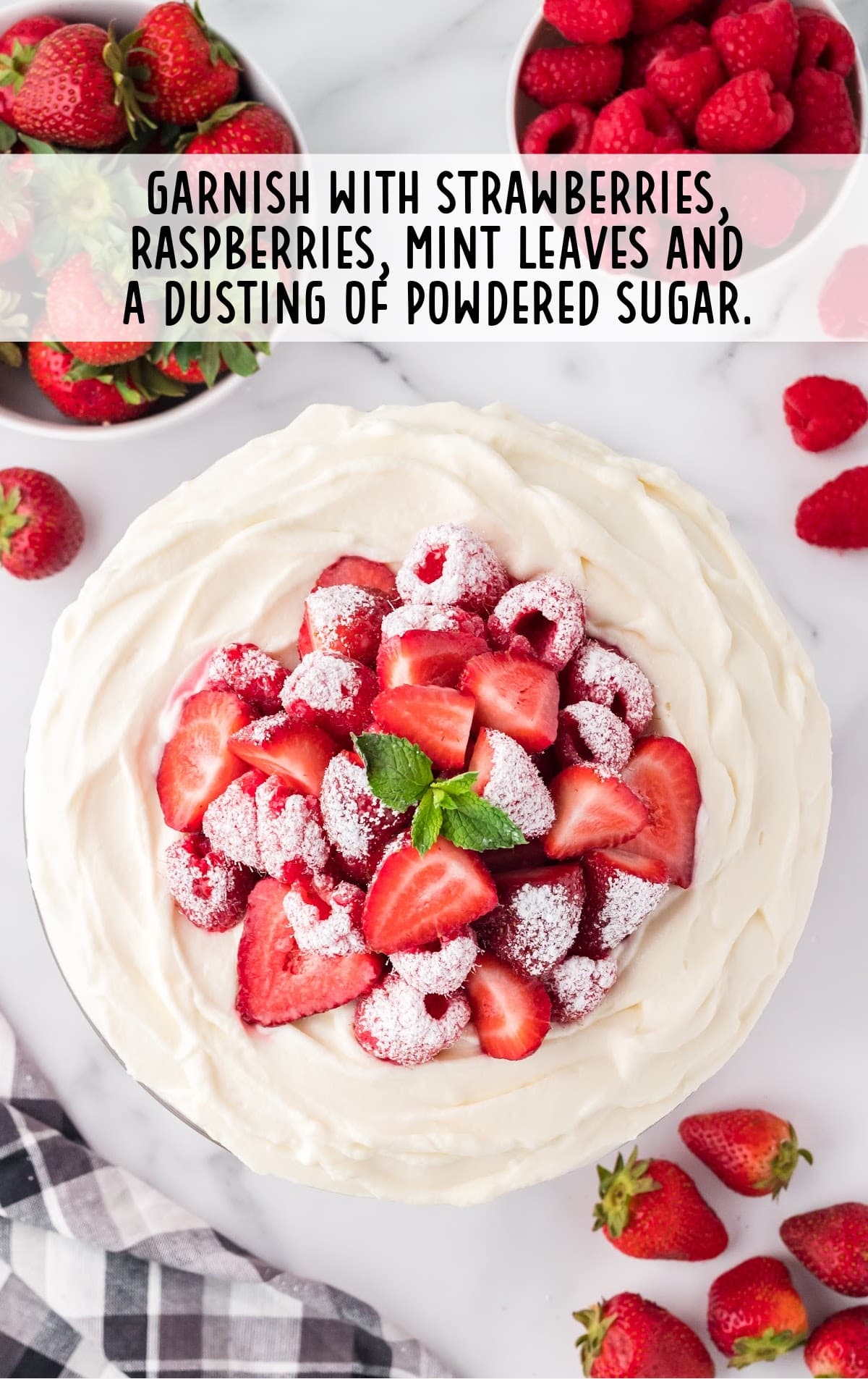 trifle garnished with fresh strawberries, raspberries, fresh mint leaves, and a dusting of powdered sugar