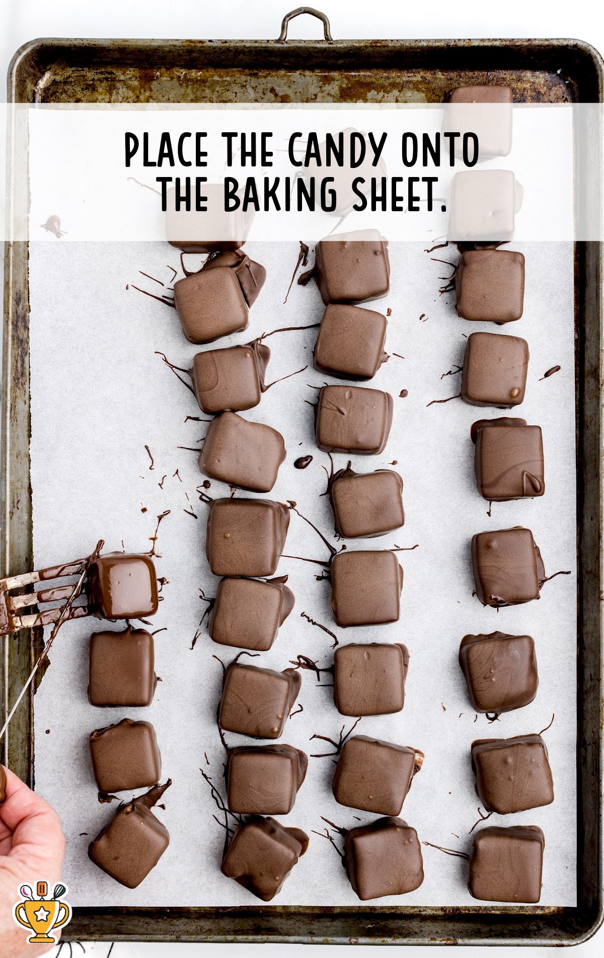 chocolate coated cool whip candy placed onto a parchment paper lined baking sheet