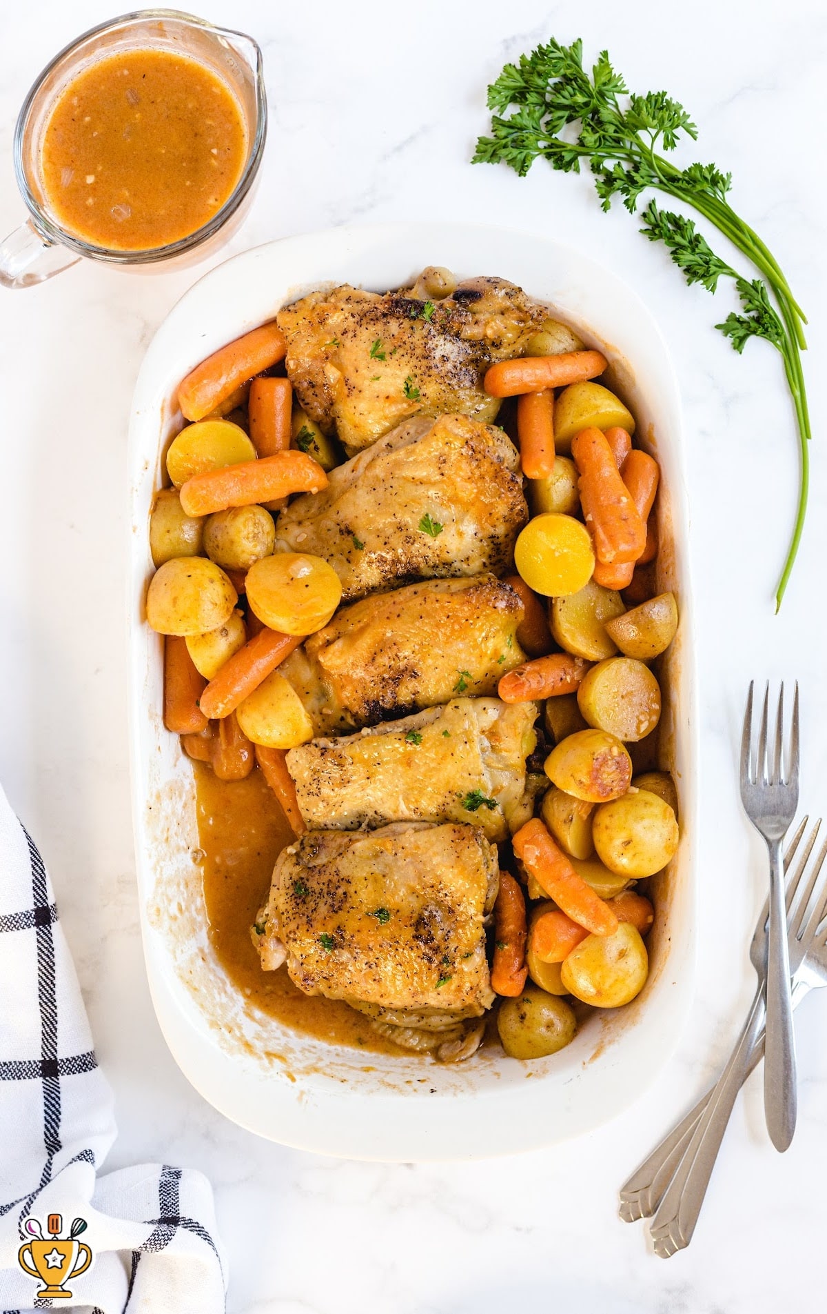 close up overhead shot of a baking dish of Crockpot Chicken Recipe served over potatoes and carrots