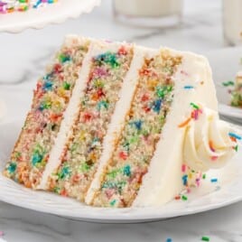 a slice of 3-layer funfetti cake on a white plate