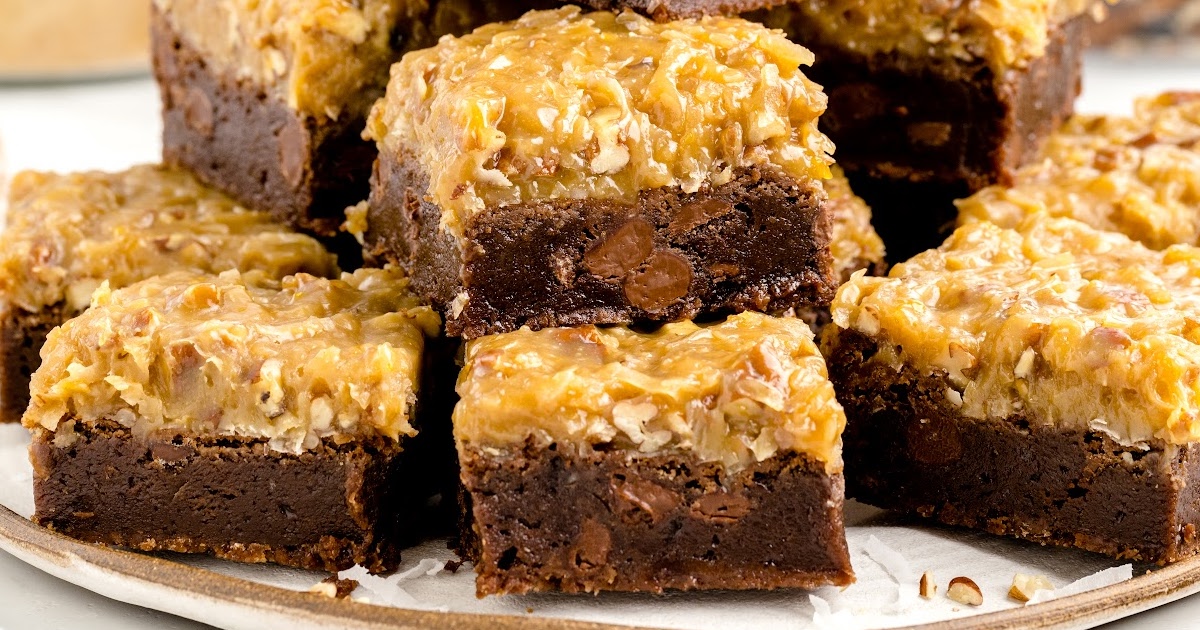 close up shot of German Chocolate Brownies stacked on top of each other on a tray with one having a bite taken out of it