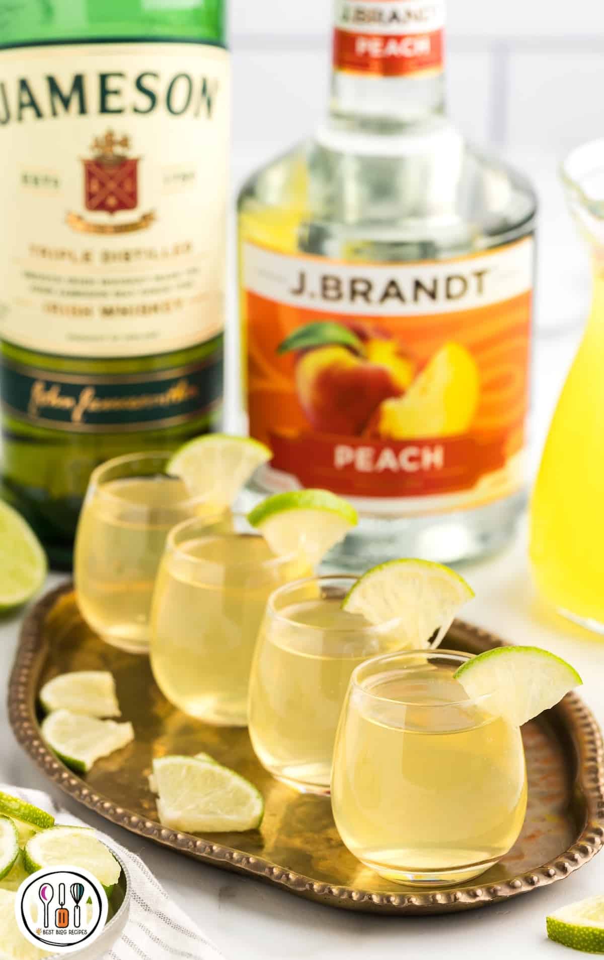 a close up shot of Green Tea Shots in a glass cup garnished with a slice of lime on a tray